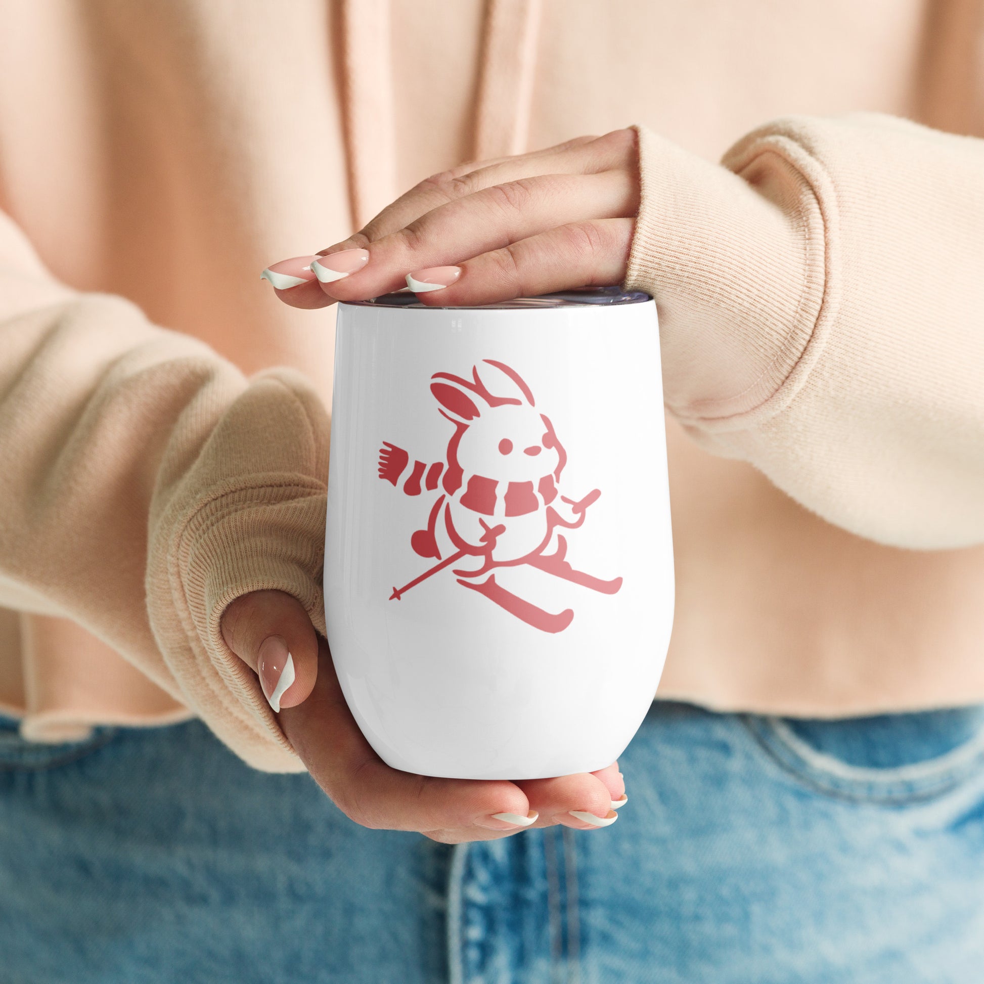 Image of women's hands holding wine tumbler with "Ski Bunny" graphic.