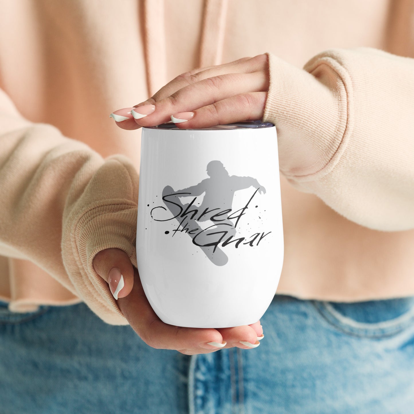 Image of women's hands holding wine tumbler with "Shred the Gnar" graphic.