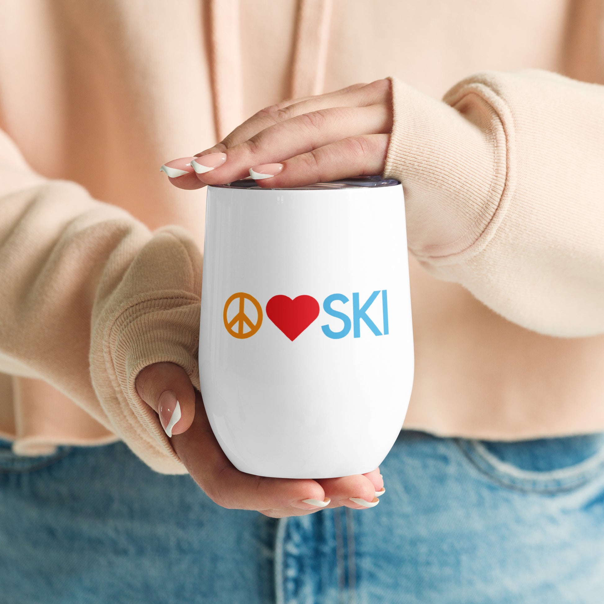 Image of women's hands holding wine tumbler with "Peace | Love | SKI" graphic.